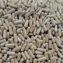 A close-up, top-down view of a dense pile of beige capsules or pills filling the entire frame. 7 mushroom blend capsules vege caps