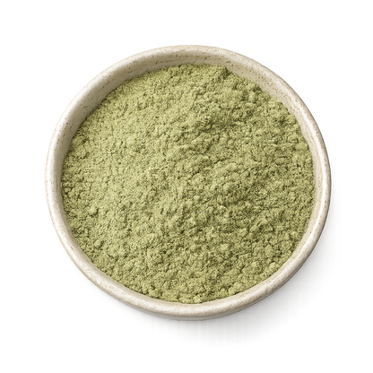 Green powder in a beige bowl on a white background